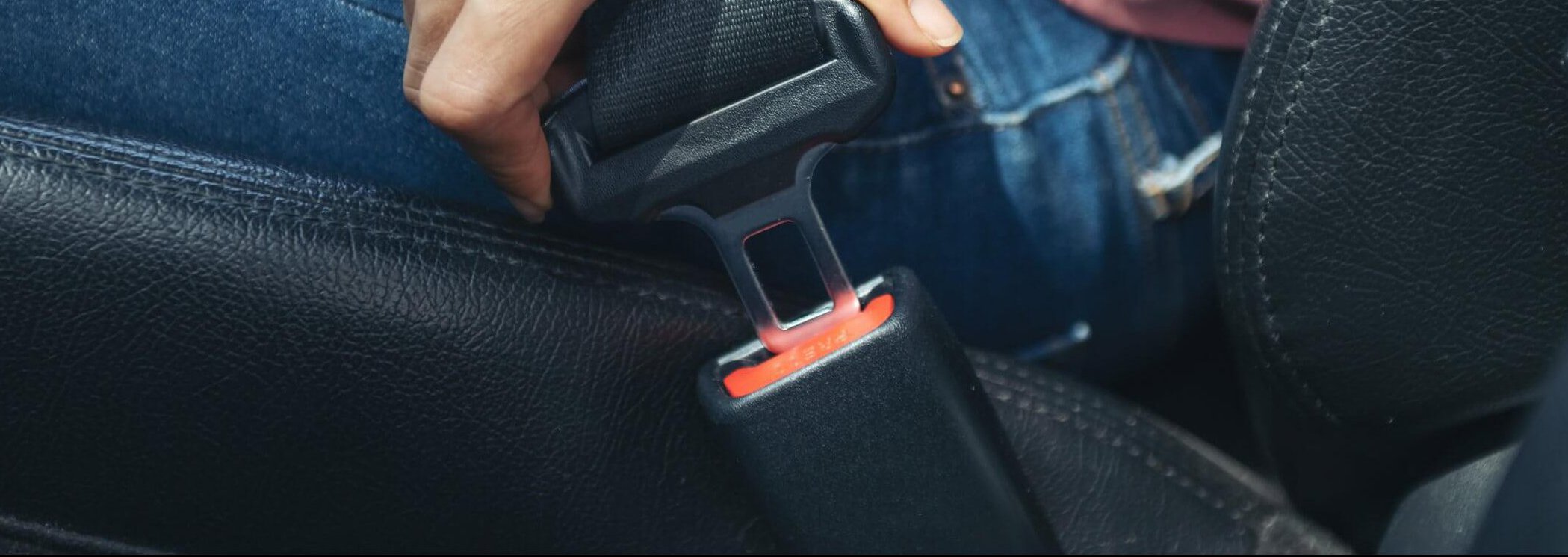 Element of car seat belt with selective focus on blurred background.  Automobile interior with chrome belt buckle and black seat belt. passenger  safety in a car. Fasten the belts human security Stock